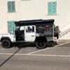 Land Rover Defender 110 op reis met side storage box uitgeklapt als kookkist