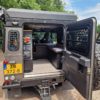 Land Rover Defender 110 mit Camper-Interieur und geöffneter Heckklappe