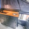 Aluminium-Küchenschrank mit Multiplex-Arbeitsplatte, eingebautem Kocher und Spüle in einem Defender 110