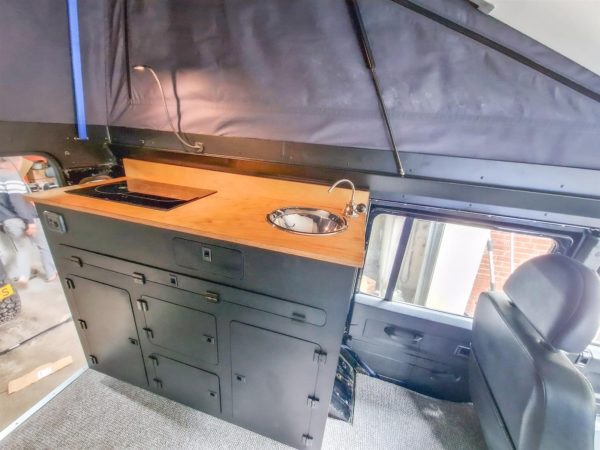 Aluminium-Küchenschrank mit Multiplex-Arbeitsplatte, eingebautem Kocher und Spüle in einem Defender 110