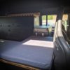Niedriger Seitenschrank als Sitzbank und Schlafplatz in einem Land Rover Defender 110